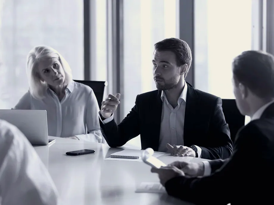 Directors in discussion around a boardroom table.