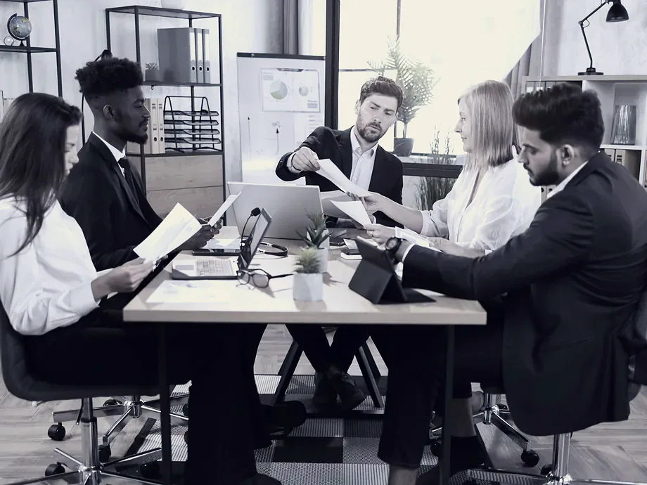 An executive team working through papers together at a table.