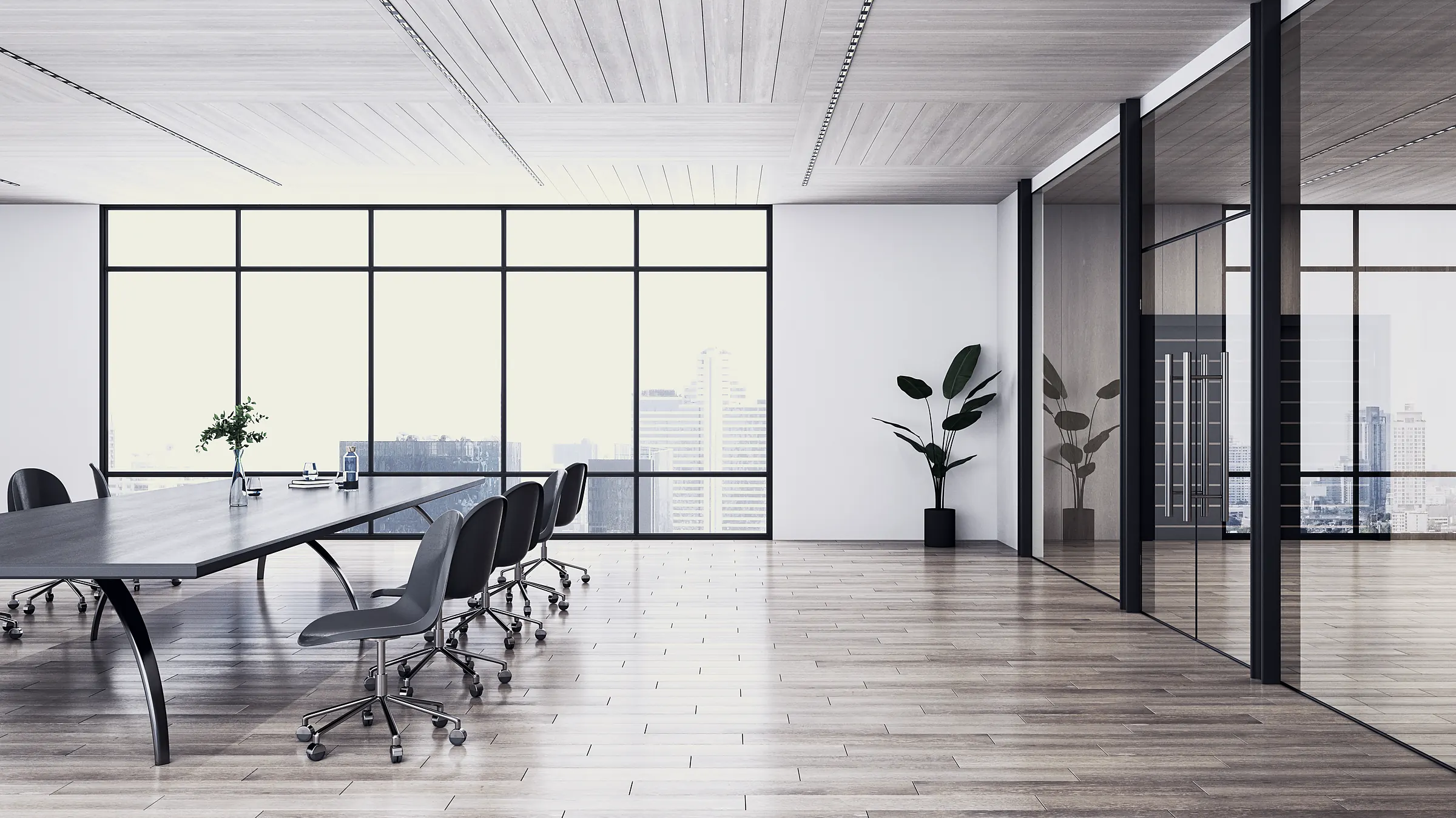 A spacious private boardroom set for a small cohort, glass partitions and a city view.