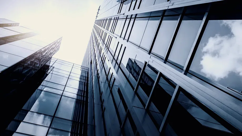 Glass towers of a financial district seen from below.