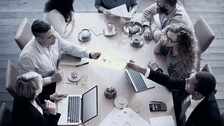 A leadership team working through a plan around one table.